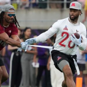 AFC running back Joe Mixon of the Houston Texans (28) carries the ball against NFC linebacker Fred Warner of the San Francisco 49ers (54) during the 2025 Pro Bowl Games at Camping World Stadium.