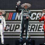 Shane van Gisbergen celebrates on the podium after winning the NASCAR Cup Series Mexico alongside second place driver Christopher Bell and third place driver Chase Elliott during the NASCAR Cup Series Mexico City Race at Autodromo Hermanos Rodriguez.