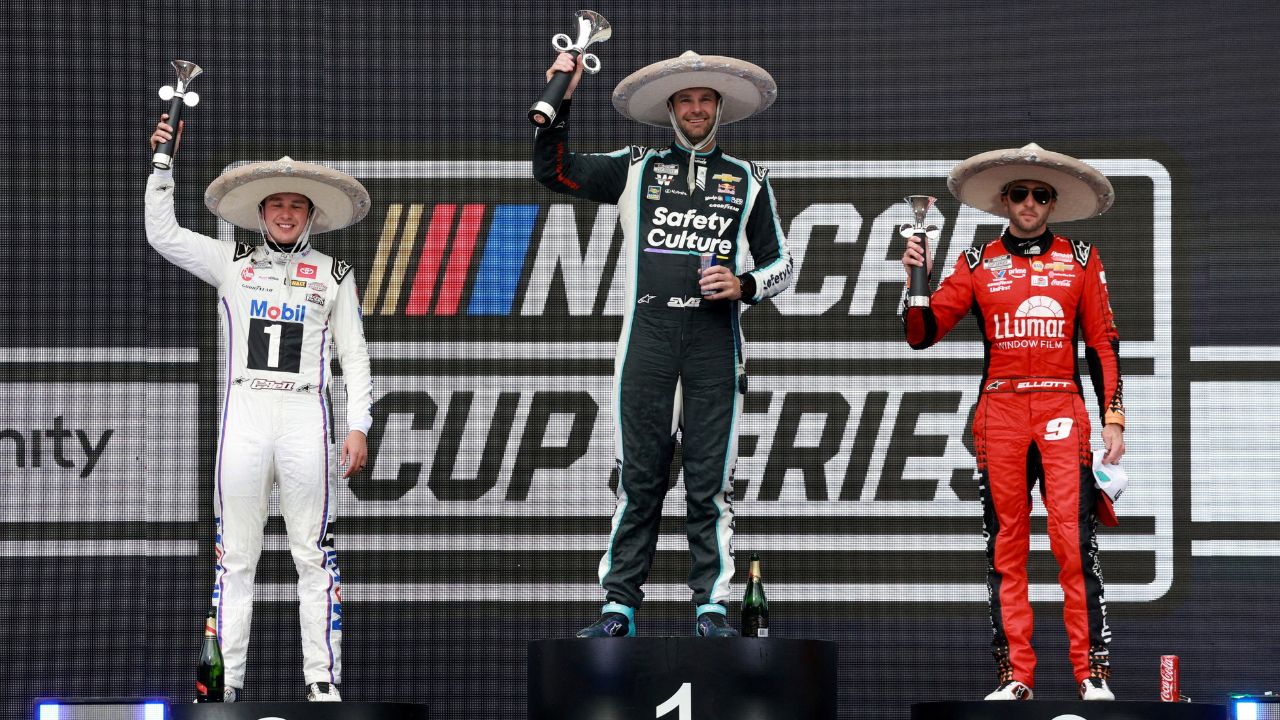 Shane van Gisbergen celebrates on the podium after winning the NASCAR Cup Series Mexico alongside second place driver Christopher Bell and third place driver Chase Elliott during the NASCAR Cup Series Mexico City Race at Autodromo Hermanos Rodriguez.