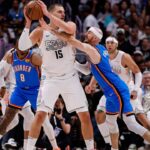 Denver Nuggets center Nikola Jokic (15) controls the ball under pressure form Oklahoma City Thunder guard Alex Caruso (9) in the second quarter during game six of the second round for the 2025 NBA Playoffs at Ball Arena.