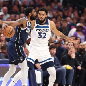 Dallas Mavericks guard Kyrie Irving (11) dribbles against Minnesota Timberwolves center Karl-Anthony Towns (32) during the first quarter of game four of the western conference finals for the 2024 NBA playoffs at American Airlines Center
