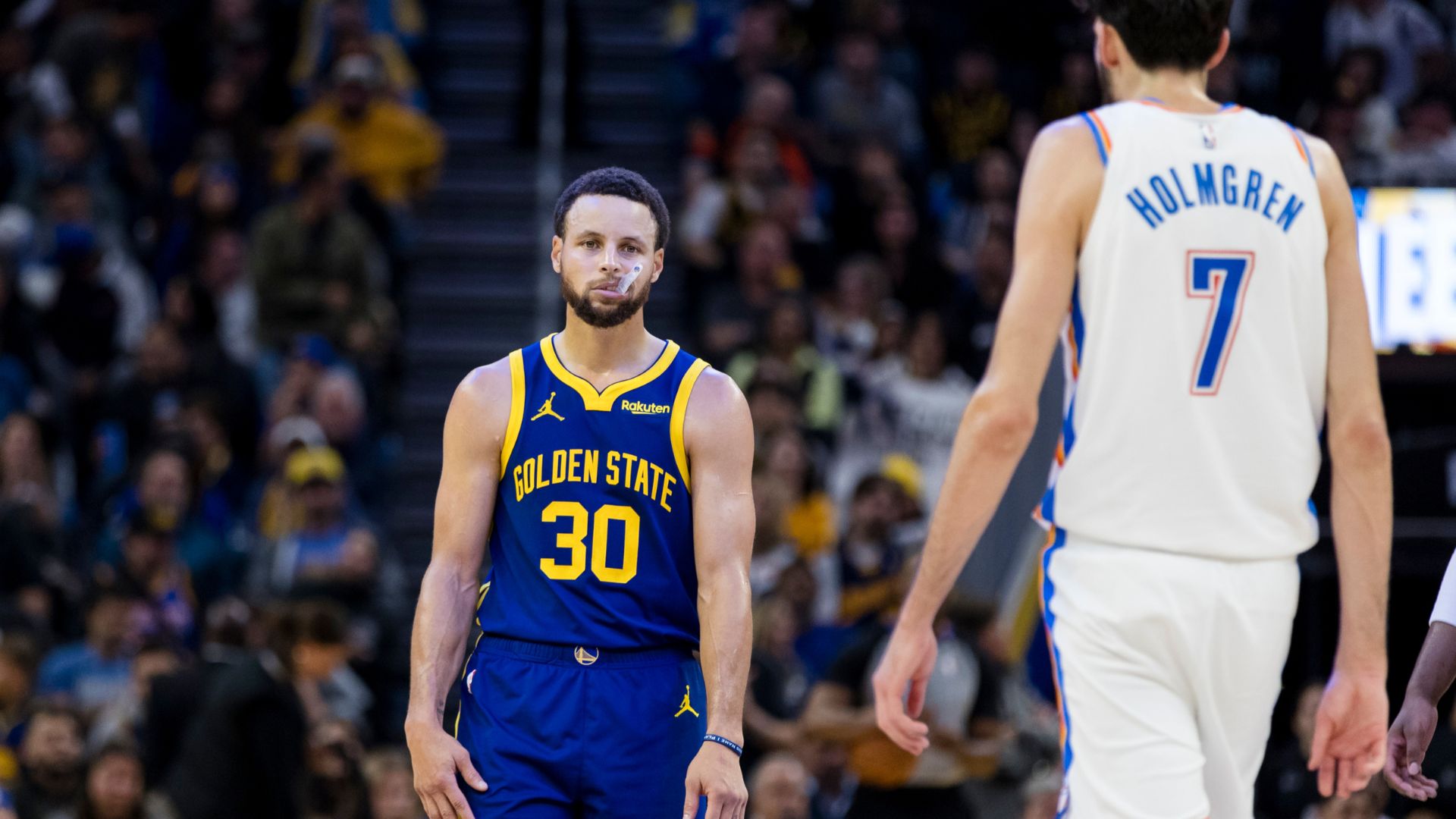 Golden State Warriors guard Stephen Curry (30) and Oklahoma City Thunder center Chet Holmgren (7) on the court during the second half at Chase Center.
