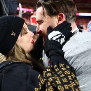 Recording artist Taylor Swift and Kansas City Chiefs tight end Travis Kelce (87) react after the AFC Championship game against the Buffalo Bills at GEHA Field at Arrowhead Stadium.