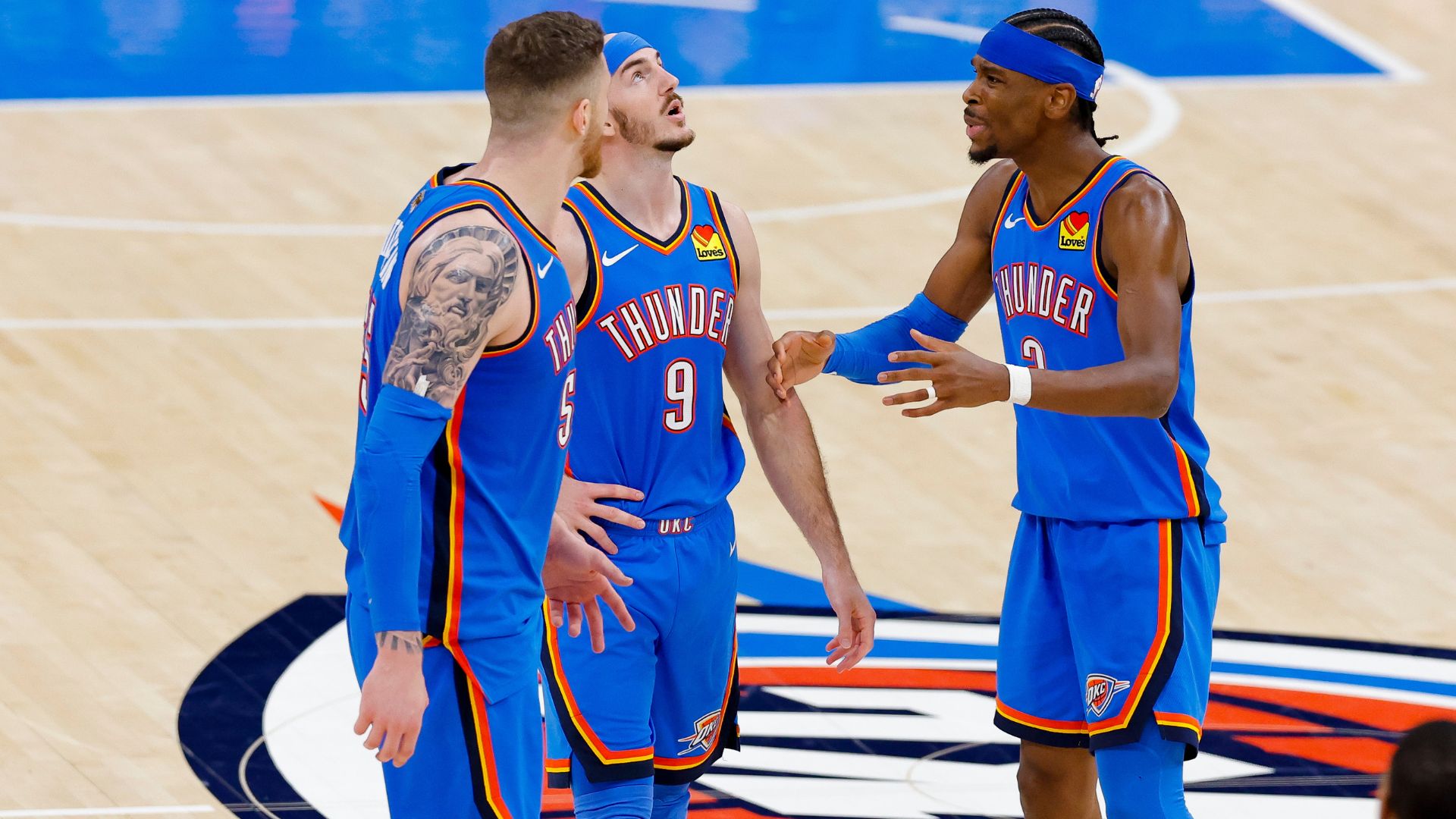 Jun 8, 2025; Oklahoma City, Oklahoma, USA; Oklahoma City Thunder center Isaiah Hartenstein (55) and guard Alex Caruso (9) and guard Shai Gilgeous-Alexander (2) talk during the third quarter against the Indiana Pacers in game two of the 2025 NBA Finals at Paycom Center.