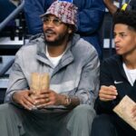 Carmelo Anthony and his son, Kiyan, watch the Don Bosco Prep Ironmen compete against the McEachern Indians in a game during the 50th annual City of Palms Classic at Suncoast Credit Union Arena in Fort Myers on Tuesday, Dec. 19, 2023. Kiyan Anthony and the Long Island Luthern Crusaders defeated Westminster Academy earlier in the day. Mandatory Credit: Imagn Images