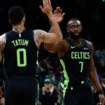 Boston Celtics guard Jaylen Brown (7) high fives forward Jayson Tatum (0) after the Cleveland Cavaliers called a timeout during the first quarter at TD Garden