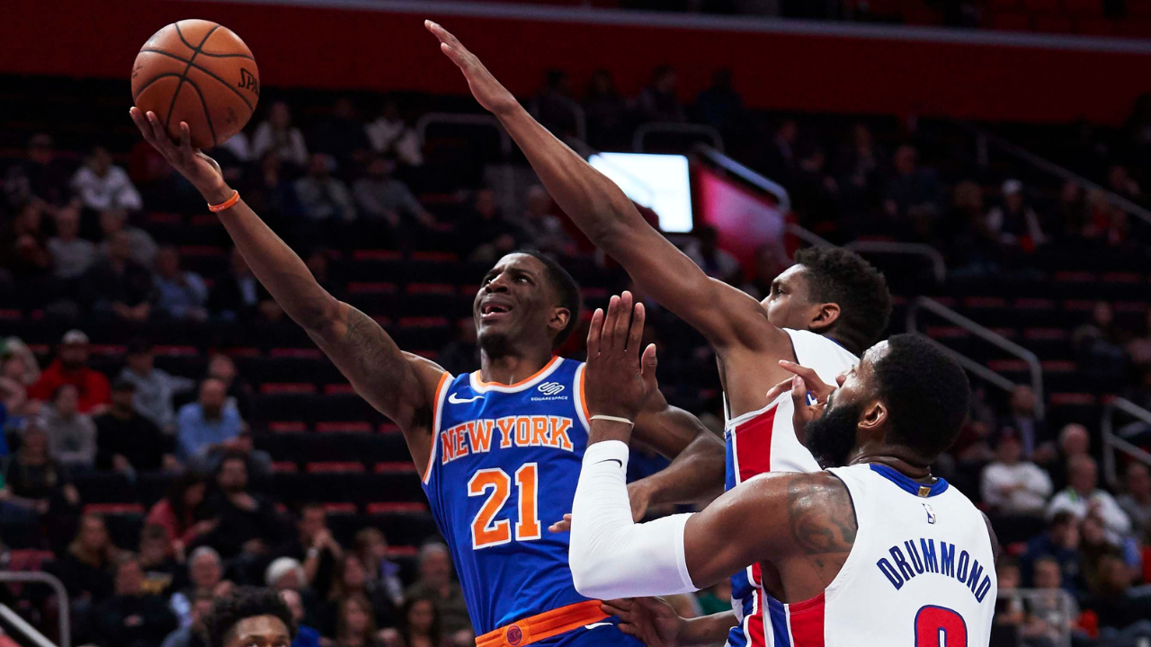 Nov 27, 2018; Detroit, MI, USA; New York Knicks guard Damyean Dotson (21) goes to the basket on Detroit Pistons guard Langston Galloway (9) and center Andre Drummond (0) in the second half at Little Caesars Arena. Mandatory Credit: Rick Osentoski-Imagn Images