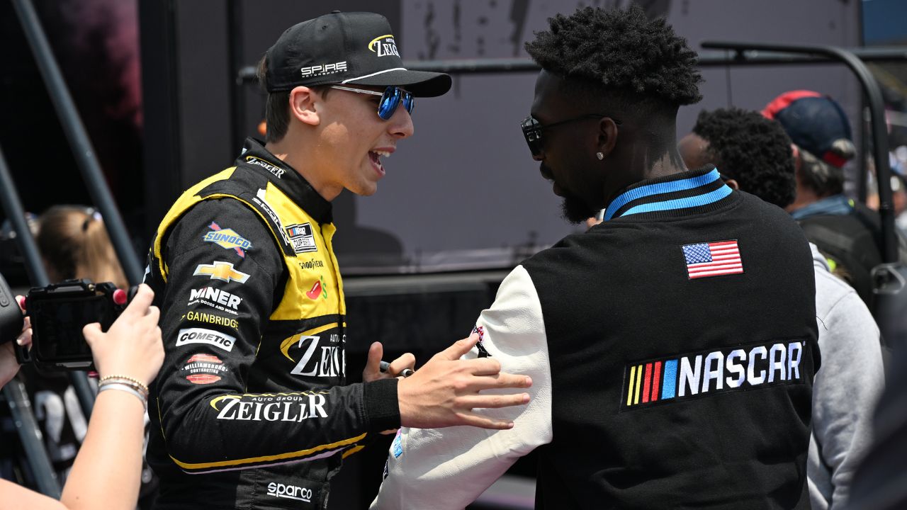 NASCAR Cup Series driver Carson Hocevar (77) greets Detroit Lions safety Kerby Joseph during driver introductions before the start of the FireKeepers Casino 400 at Michigan International Speedway.