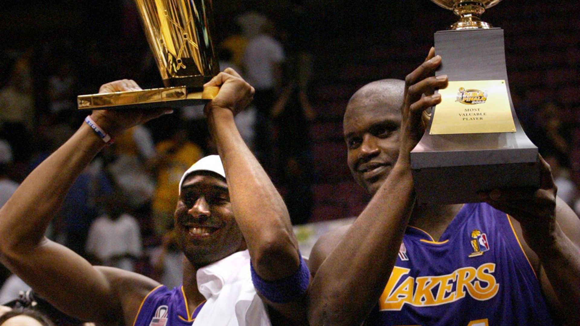 June 12, 2002; East Rutherford, NJ; The Lakers Kobe Bryant holds up the Championship trophy along with teammate Shaquille O'Neal who holds up his third MVP trophy.