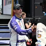 NASCAR Cup Series driver Denny Hamlin (11) greets Detroit Lions safety Kerby Joseph during driver introductions before the start of the FireKeepers Casino 400 at Michigan International Speedway.