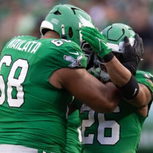 Philadelphia Eagles running back Saquon Barkley (26) celebrates with offensive tackle Jordan Mailata (68) after rushing for 167 yards in a game against the Dallas Cowboys at Lincoln Financial Field.