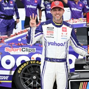 NASCAR Cup Series driver Denny Hamlin (11) celebrates with his team, holding up three fingers, one for each of his victories at Michigan International Speedway, after winning the FireKeepers Casino 400.