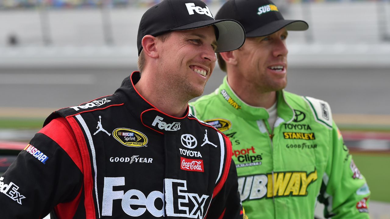 NASCAR Sprint Cup Series driver Denny Hamlin (L) and Carl Edwards (R) look on during qualifying for the Coke Zero 400 powered by Coca-Cola at Daytona International Speedway.