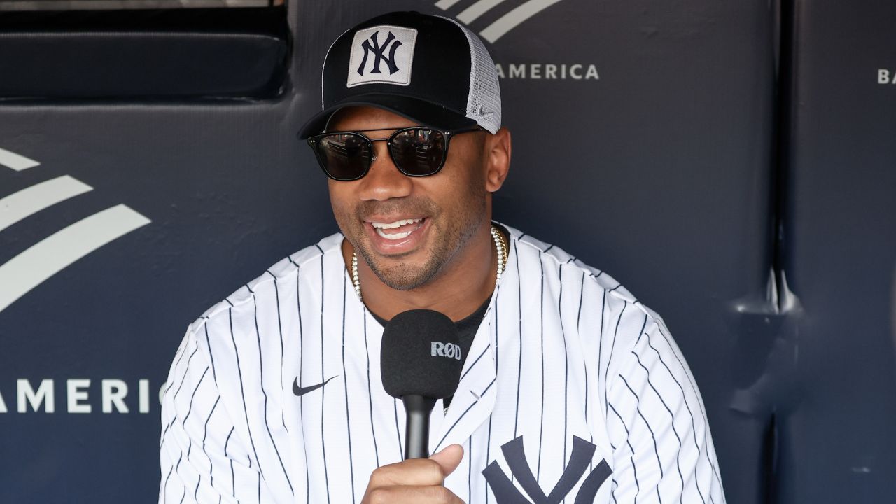 New York Giants quarterback Russell Wilson is interviewed prior to the game between the New York Mets and the New York Yankees at Yankee Stadium.