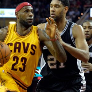 Nov 19, 2014; Cleveland, OH, USA; Cleveland Cavaliers forward LeBron James (23) drives against San Antonio Spurs forward Tim Duncan (21) and forward Kawhi Leonard (2) in the second quarter at Quicken Loans Arena