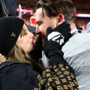 Recording artist Taylor Swift and Kansas City Chiefs tight end Travis Kelce (87) react after the AFC Championship game against the Buffalo Bills at GEHA Field at Arrowhead Stadium.