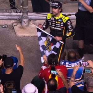 NASCAR Cup Series driver Ryan Blaney (12) heads into the stands to give away the checkered flag after winning the Cracker Barrel 400 NASCAR Cup Series race at Nashville Superspeedway in Lebanon, Tenn., Sunday, June 1, 2025.