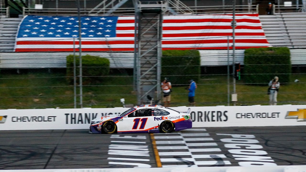 Denny Hamlin (11) crosses the finish line to win the Pocono 350 Cup Series at Pocono Raceway.