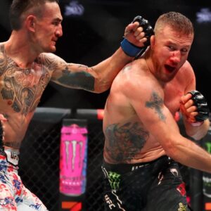 Max Holloway (blue gloves) fights Justin Gaethje (red gloves) during UFC 300 at T-Mobile Arena.