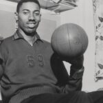 Vintage 1960 s capture of Wilt Chamberlain smiling while spinning a basketball