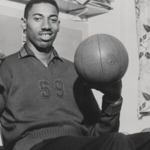 Vintage 1960 s capture of Wilt Chamberlain smiling while spinning a basketball