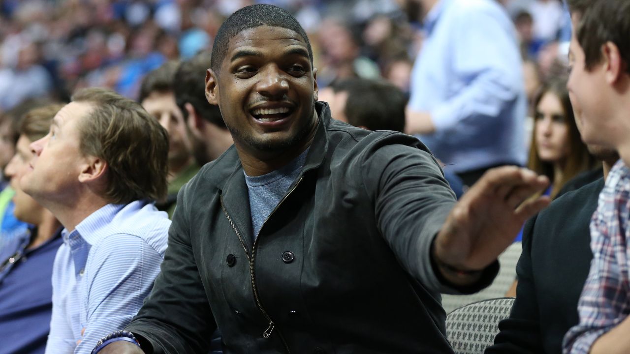 Michael Sam sits courtside to watch the Dallas Mavericks play against the Minnesota Timberwolves at American Airlines Center.