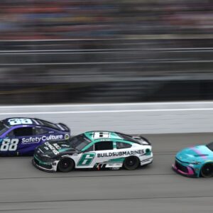 NASCAR Cup Series drivers Shane van Gisbergen (88) Brad Keselowski (6) and driver Bubba Wallace (23) race down the main straightaway during stage three of the FireKeepers Casino 400 at Michigan International Speedway.