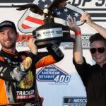 NASCAR Cup Series driver Chase Briscoe raises the winner’s trophy in victory lane after winning The Great American Getaway 400 at Pocono Raceway.