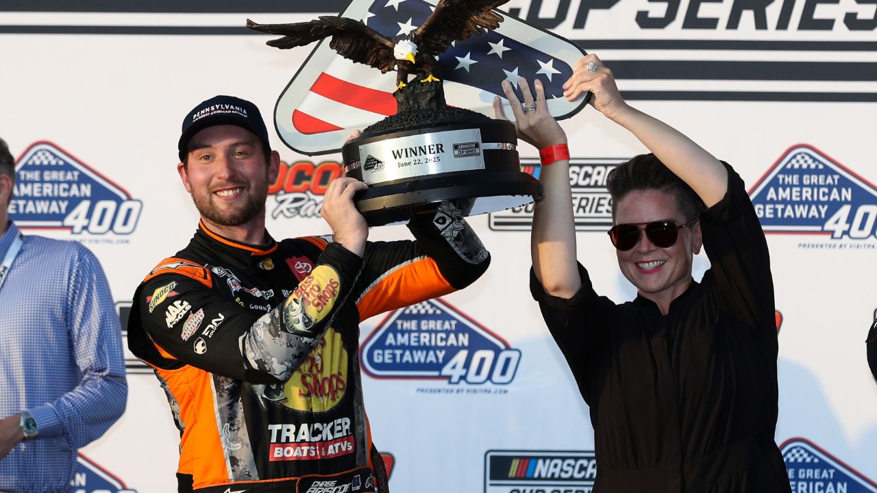 NASCAR Cup Series driver Chase Briscoe raises the winner’s trophy in victory lane after winning The Great American Getaway 400 at Pocono Raceway.
