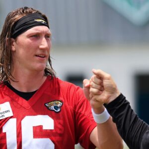 Jacksonville Jaguars quarterback Trevor Lawrence (16) fist bumps executive vice president of football operations Tony Boselli during the first organized team activity at Miller Electric Center Monday, May 19, 2025 in Jacksonville, Fla.