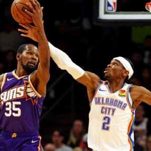 Phoenix Suns forward Kevin Durant (35) and Oklahoma City Thunder guard Shai Gilgeous-Alexander (2) go for the ball during the second quarter at Footprint Center