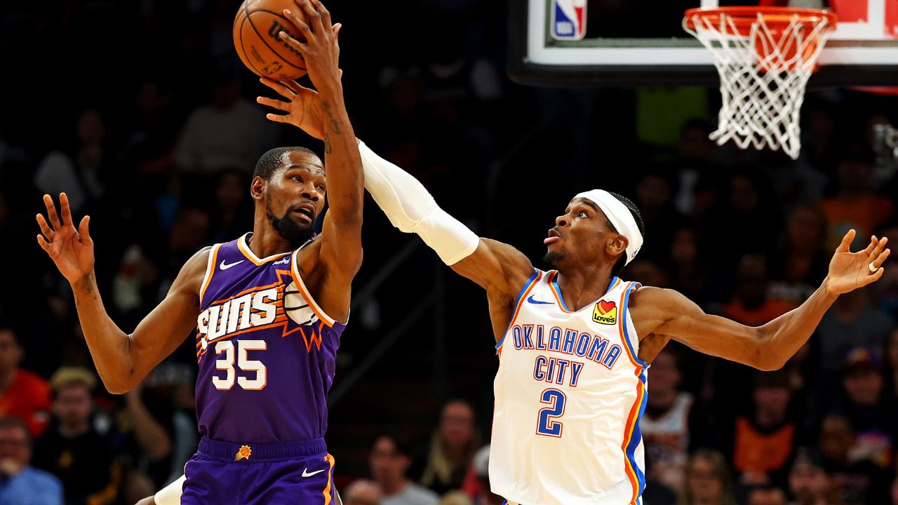 Phoenix Suns forward Kevin Durant (35) and Oklahoma City Thunder guard Shai Gilgeous-Alexander (2) go for the ball during the second quarter at Footprint Center