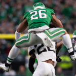 Nov 3, 2024; Philadelphia, Pennsylvania, USA; Philadelphia Eagles running back Saquon Barkley (26) leaps with the ball over Jacksonville Jaguars cornerback Jarrian Jones (22) during the second quarter at Lincoln Financial Field. Mandatory Credit: Bill Streicher-Imagn Images