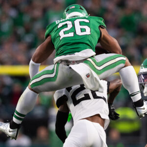 Nov 3, 2024; Philadelphia, Pennsylvania, USA; Philadelphia Eagles running back Saquon Barkley (26) leaps with the ball over Jacksonville Jaguars cornerback Jarrian Jones (22) during the second quarter at Lincoln Financial Field. Mandatory Credit: Bill Streicher-Imagn Images