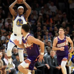 Golden State Warriors forward Jimmy Butler III (10) makes a pass in front of Phoenix Suns guard Devin Booker (1) during the first half at Footprint Center.