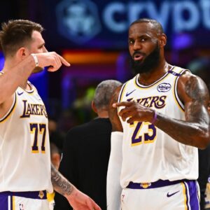 Los Angeles Lakers guard Luka Doncic (77) and Los Angeles Lakers forward LeBron James (23) on the sidelines against the Chicago Bulls during the first half at Crypto.com Arena.