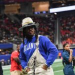 Former Auburn and NFL star Cam Newton stands on the sidelines during the Cricket Celebration Bowl game between Florida A&M University and Howard University at Mercedes-Benz Stadium in Atlanta on Dec. 16, 2023
