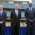 Members of the Guggenheim baseball management team pose at a press conference to announce the sale of the Los Angeles Dodgers at Dodger Stadium. From left: Stan Kasten and Mark Walter and Magic Johnson