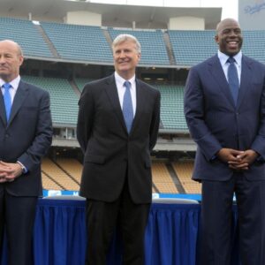 Members of the Guggenheim baseball management team pose at a press conference to announce the sale of the Los Angeles Dodgers at Dodger Stadium. From left: Stan Kasten and Mark Walter and Magic Johnson