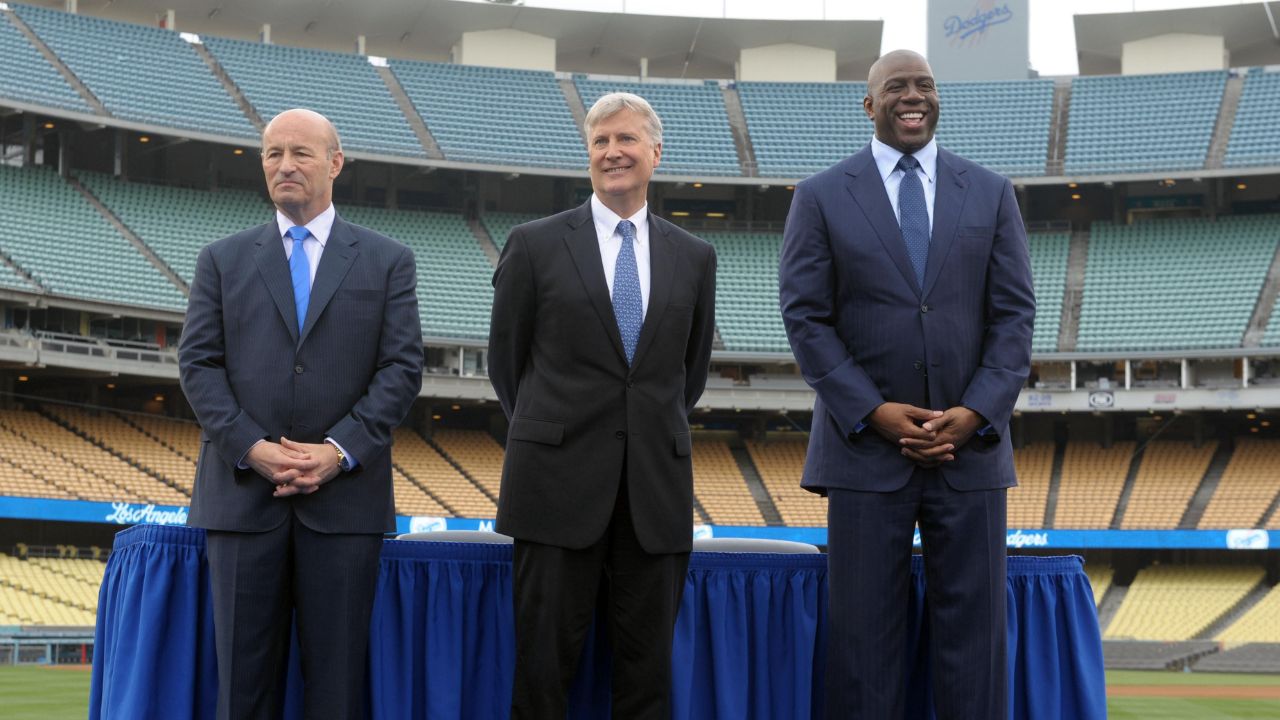 Members of the Guggenheim baseball management team pose at a press conference to announce the sale of the Los Angeles Dodgers at Dodger Stadium. From left: Stan Kasten and Mark Walter and Magic Johnson