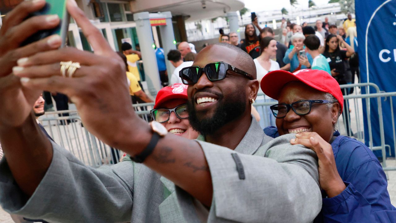 Former Miami Heat guard Dwyane Wade poses with fans in front of the Kaseya Center.