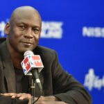 American basketball superstar Michael Jordan, owner and chairman of the Charlotte Hornets, listens at a press conference