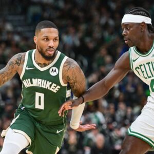 Milwaukee Bucks guard Damian Lillard (0) drives for the basket against Boston Celtics guard Jrue Holiday (4) in the first quarter at Fiserv Forum.