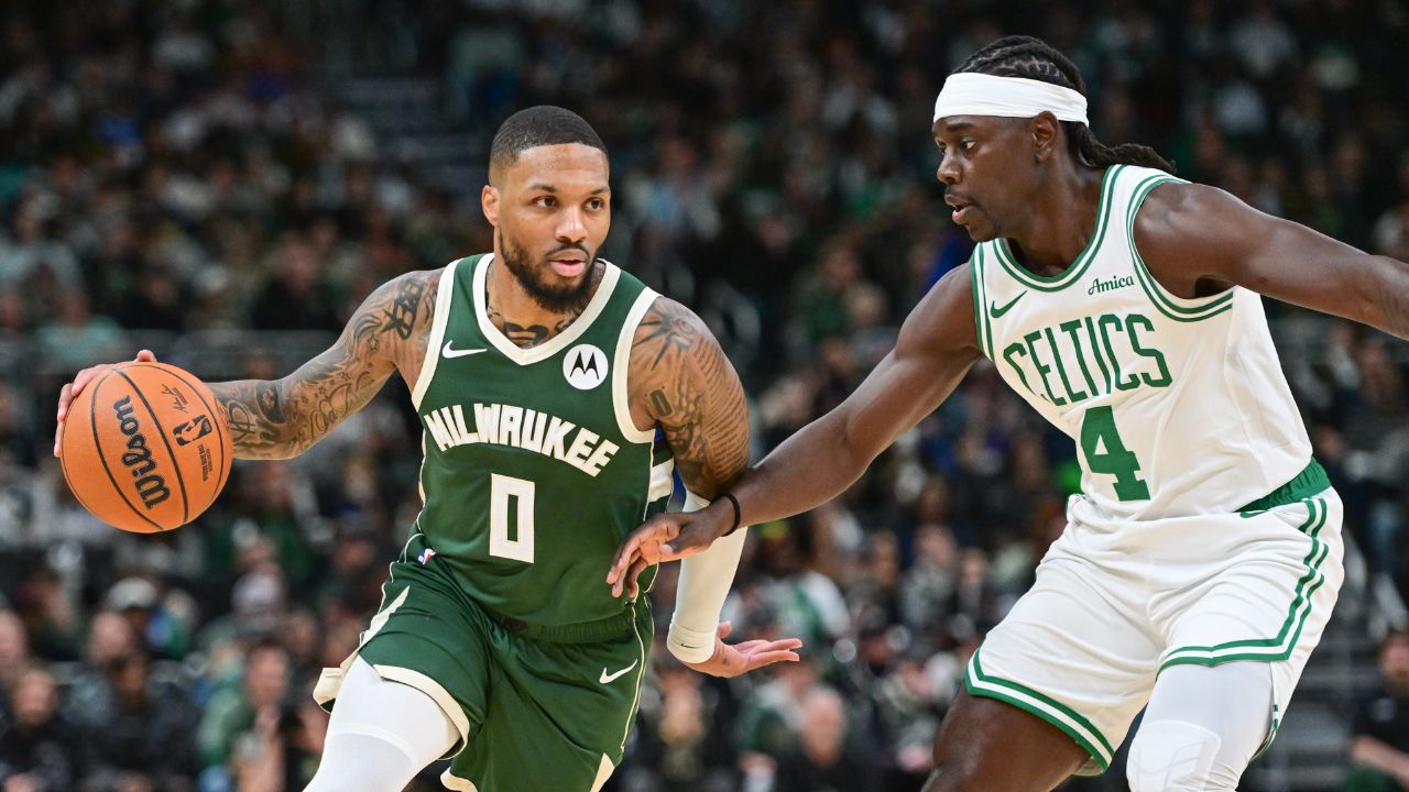 Milwaukee Bucks guard Damian Lillard (0) drives for the basket against Boston Celtics guard Jrue Holiday (4) in the first quarter at Fiserv Forum.