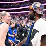Dallas Mavericks point guard Kyrie Irving talks with Dallas Wings guard Paige Bueckers (5) after the game against the Indiana Fever at the American Airlines Center.