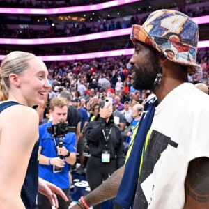 Dallas Mavericks point guard Kyrie Irving talks with Dallas Wings guard Paige Bueckers (5) after the game against the Indiana Fever at the American Airlines Center.