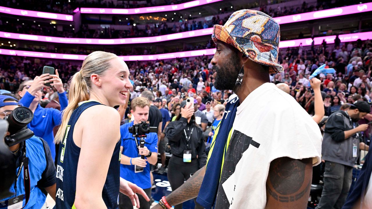 Dallas Mavericks point guard Kyrie Irving talks with Dallas Wings guard Paige Bueckers (5) after the game against the Indiana Fever at the American Airlines Center.