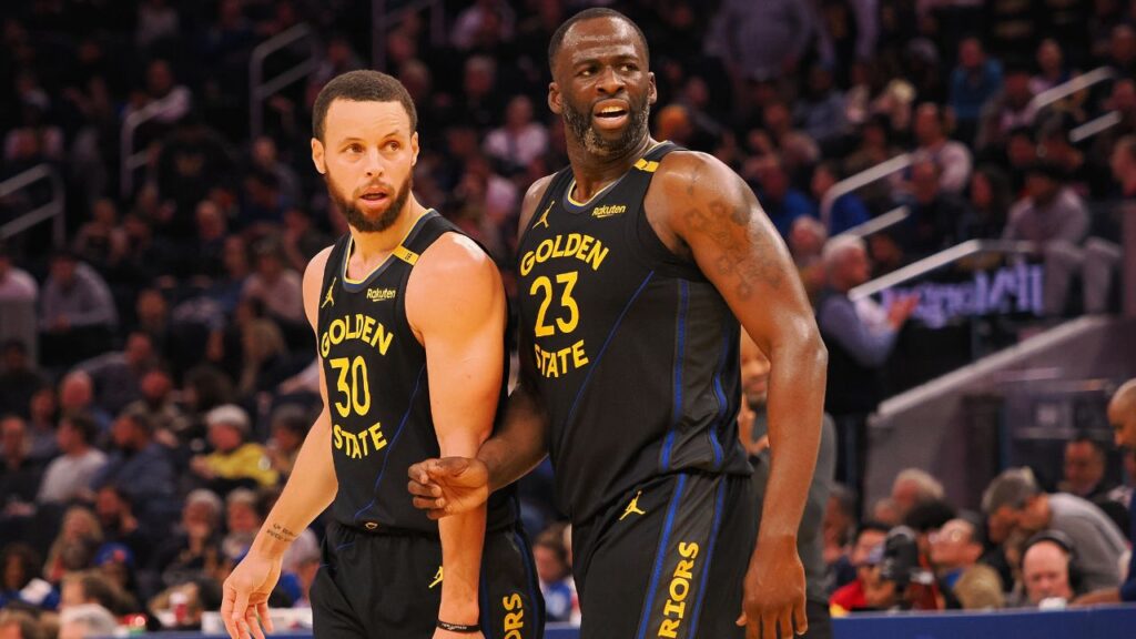 Golden State Warriors guard Stephen Curry (30) and forward Draymond Green (23) look towards an Orlando Magic player at half time at Chase Center.