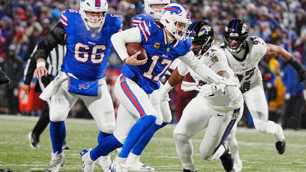 Buffalo Bills quarterback Josh Allen runs with the ball trying to avoid the reach of Baltimore Ravens defensive tackle Nnamdi Madubuike during first half action during the Buffalo Bills divisional game against the Baltimore Ravens at Highmark Stadium in Orchard Park on Jan. 19, 2025.