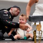 NASCAR Cup Series driver Bubba Wallace (23) kisses the bricks with his wife, Amanda Carter, and son, Becks Hayden Wallace, Sunday, July 27, 2025, following the Brickyard 400 at Indianapolis Motor Speedway.